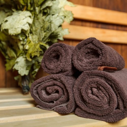Sauna for relaxation and spa therapy. Sauna for relaxation and spa therapy, towel on the wooden bench and broom on the background.